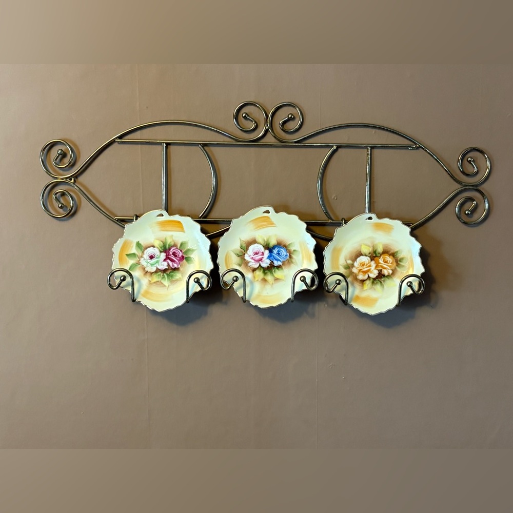 vintage hand-painted Japanese decorative plates on a brass wall-mounted display